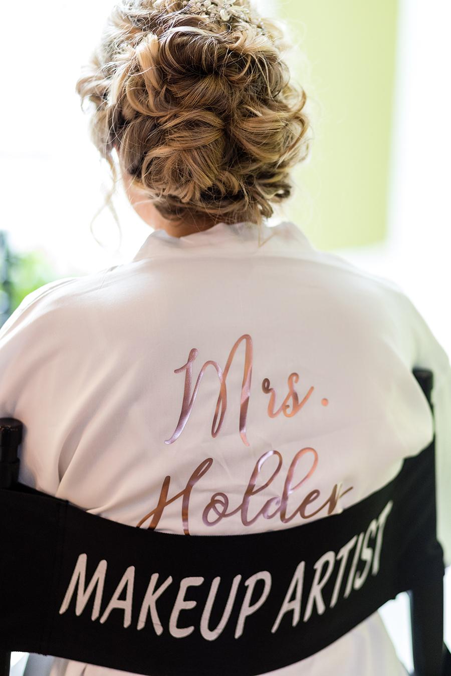bride wearing wedding hairstyle wearing robe in makeup artist chair by ashley gerrity photography and philly in love