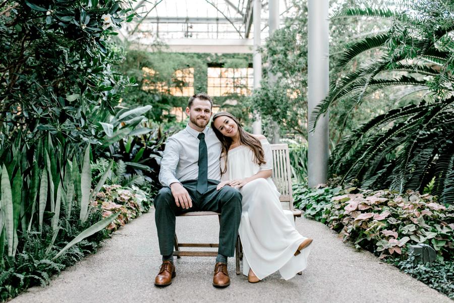 happy couple sitting on bench at longwood gardens by clicke photography and philly in love blog