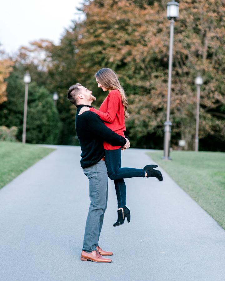 guy lifting woman into the air at park by clicke photography and philly in love blog