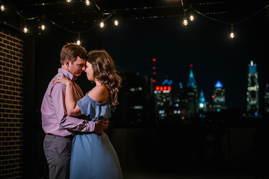 couple embrace on rooftop at night by Nicole Cordisco Photography and Philly In Love