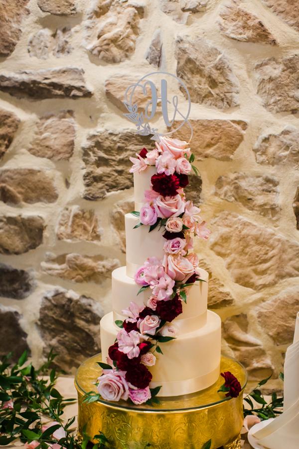 wedding cake covered in pink and red roses