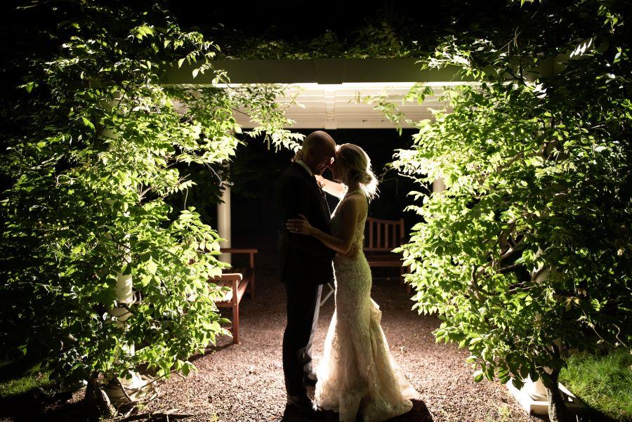 bride and groom embrace in the moonlight