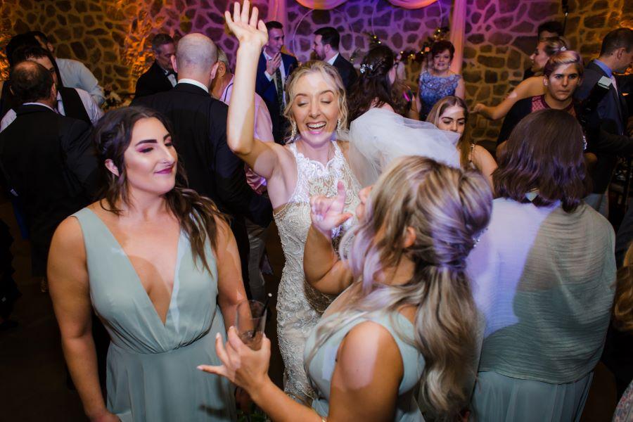 bride dances with bridesmaids at wedding