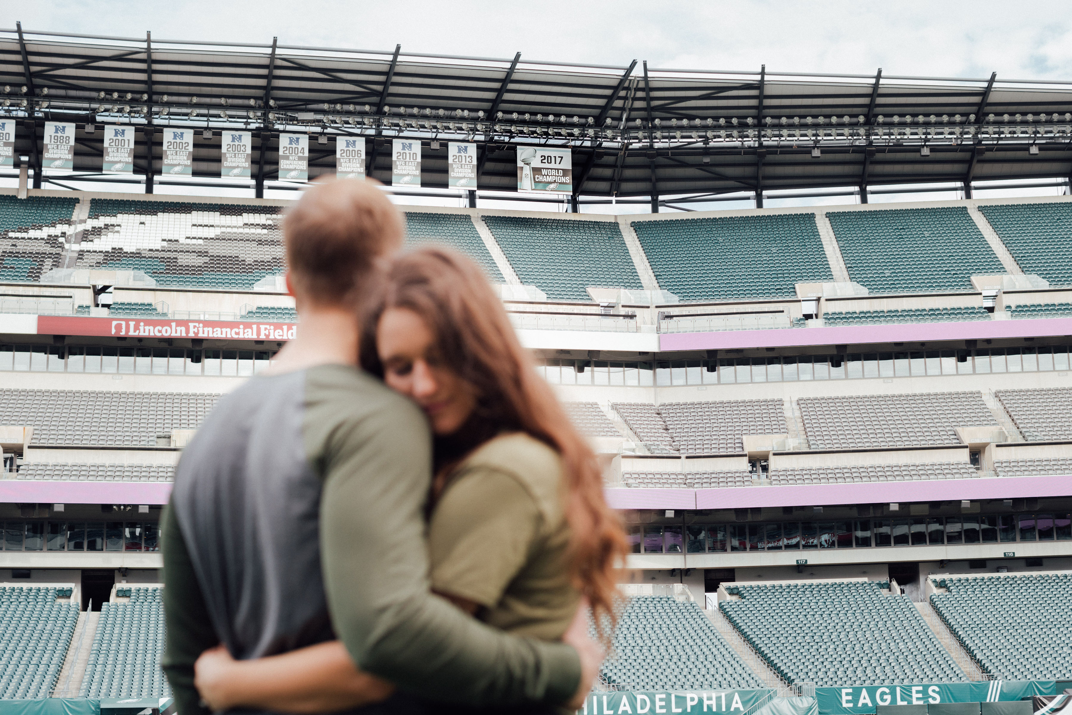 couple embrace in football stadium