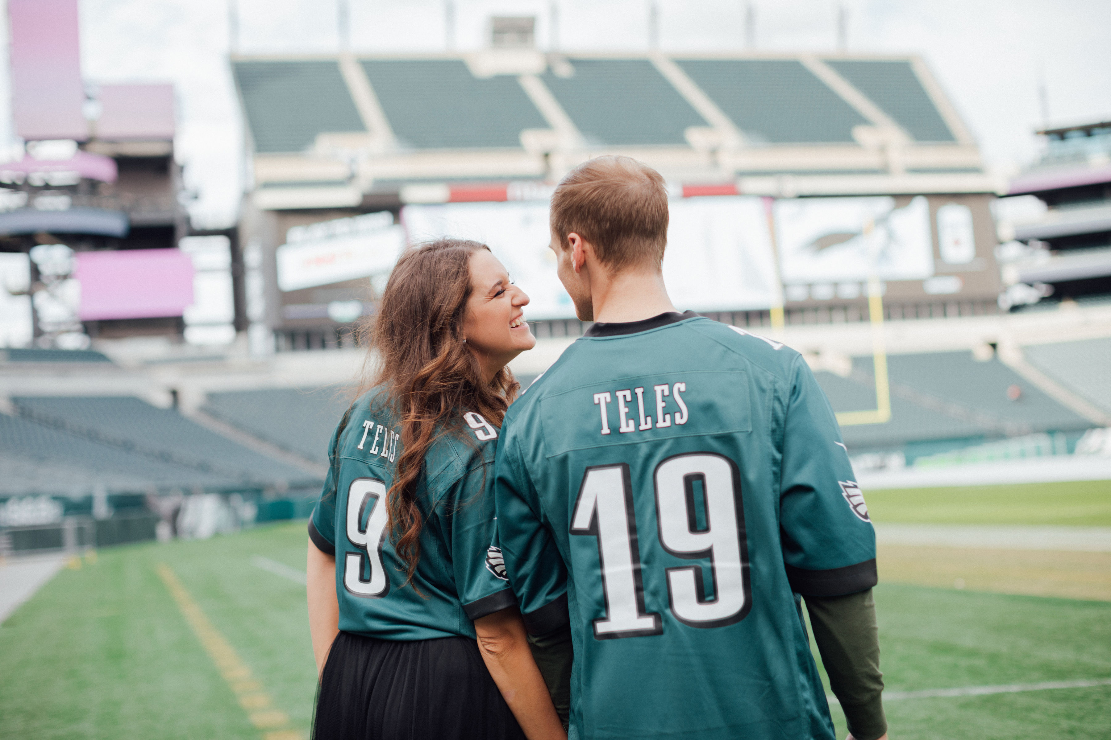 couple smiling on football field