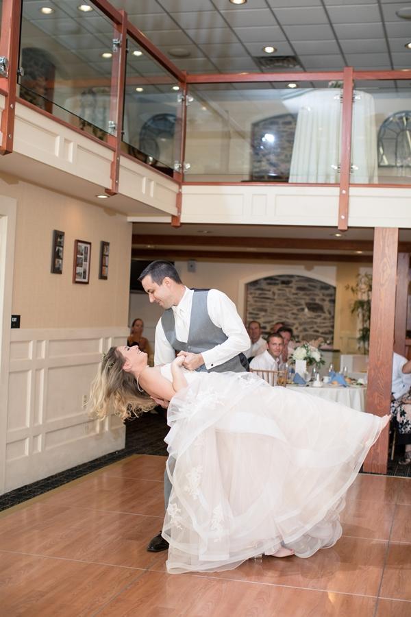 groom dips bride on dance floor