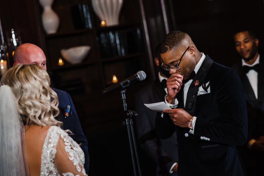 groom reads wedding vows