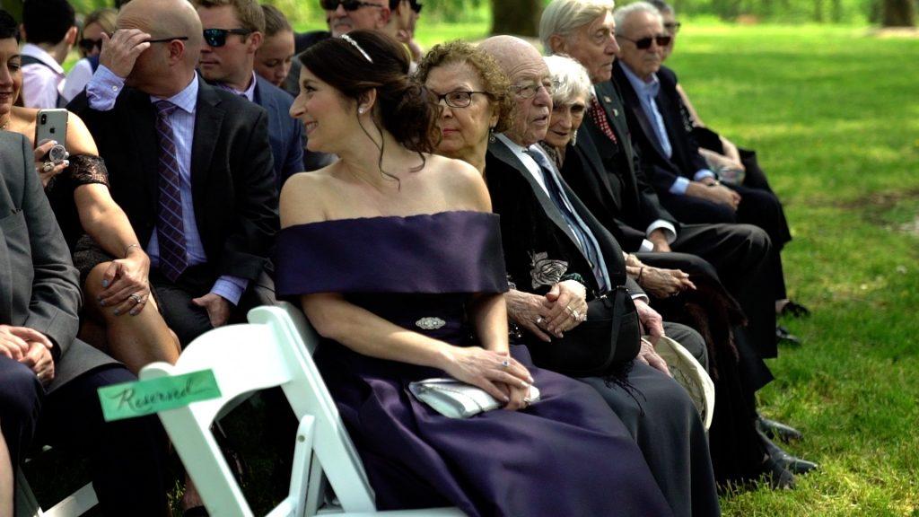 wedding guests seated on lawn at outdoor ceremony