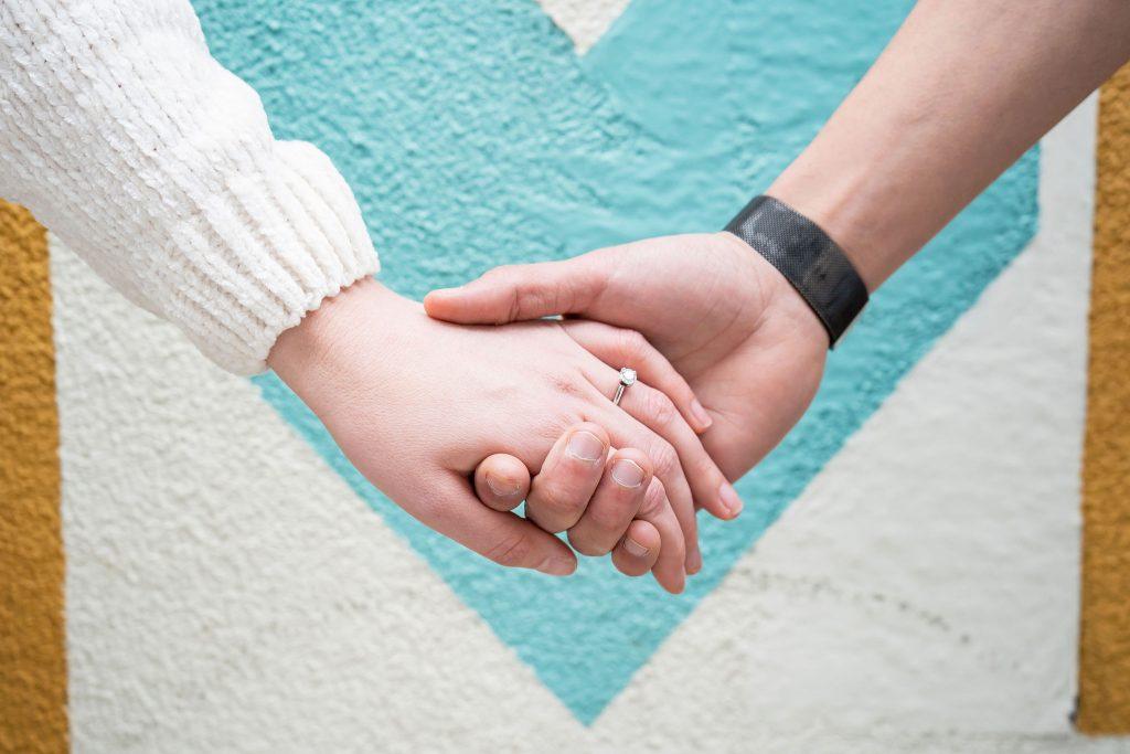 engaged couple holding hands with ring