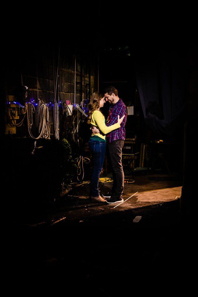 engaged couple embrace backstage