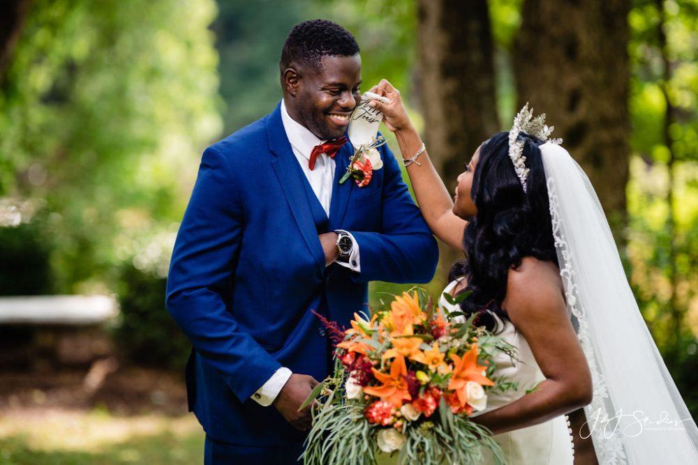 African American bride wipes African American groom with hanker chief on wedding day